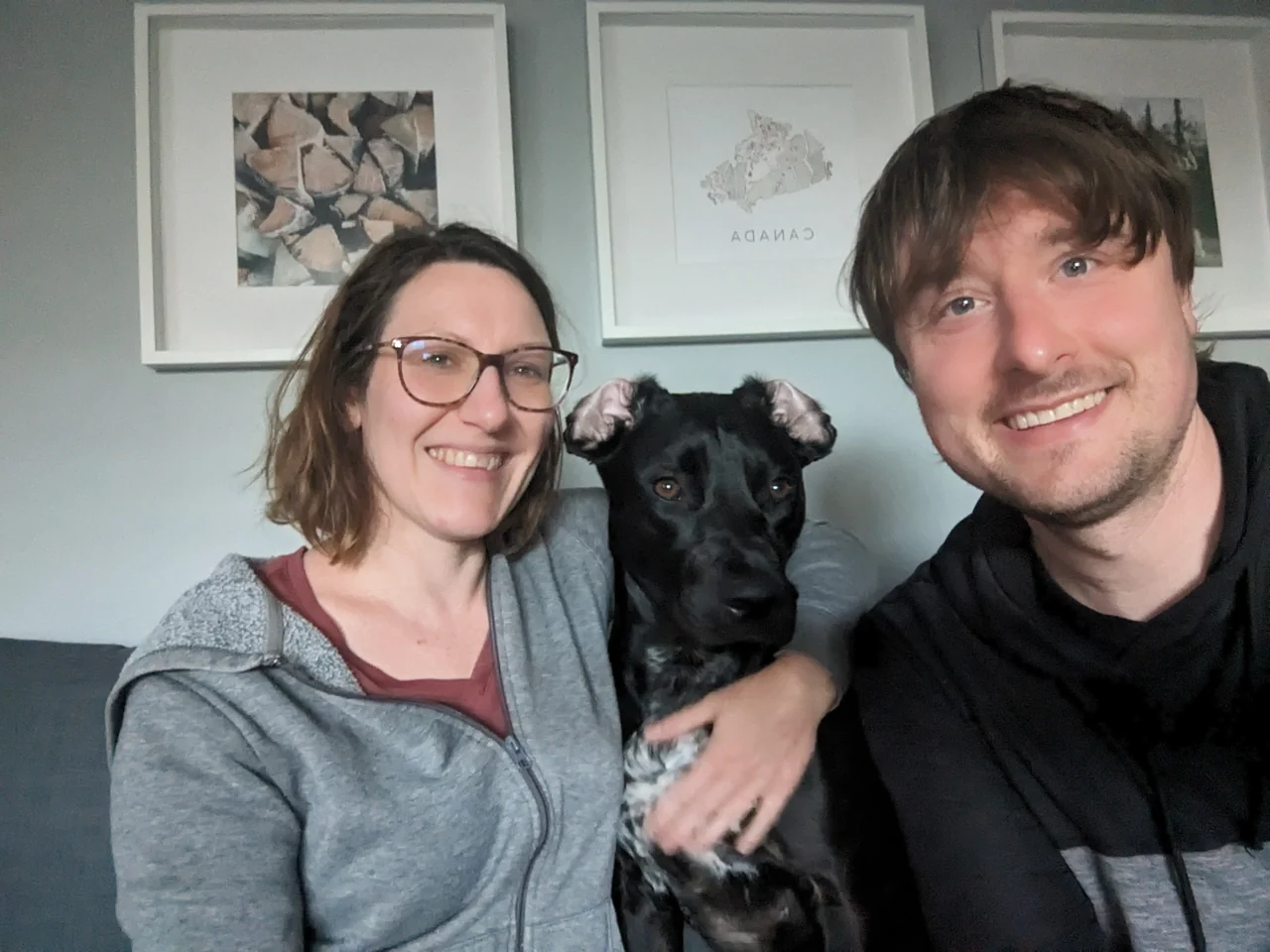 Hannah and Mike sitting on the sofa with Luna between them