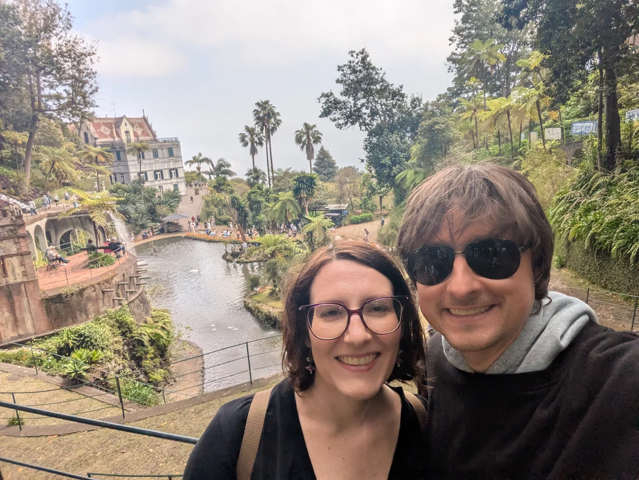 Hannah and Mike beside a garden pond and palm trees