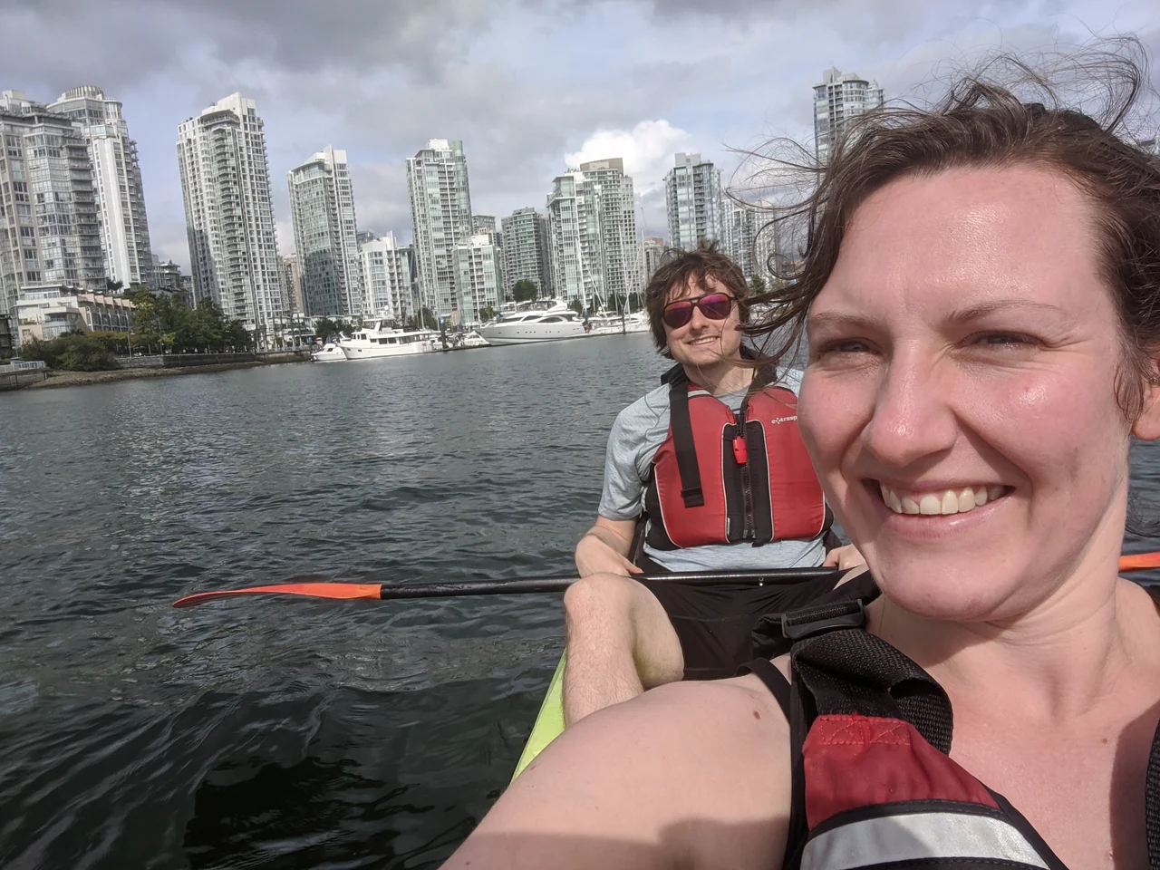 Hannah and Mike kayaking together beside the city waterfront