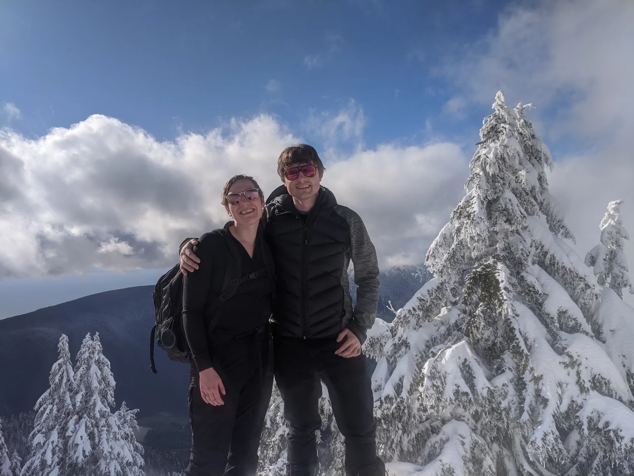 Hannah and Mike standing together among snow-covered trees